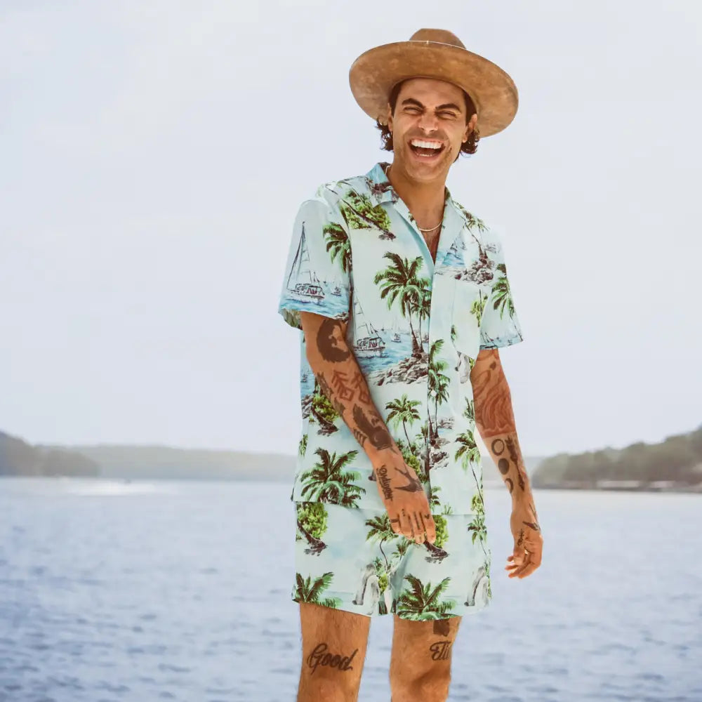 Light blue short-sleeved hawaiian shirt with palm tree and sailboat print