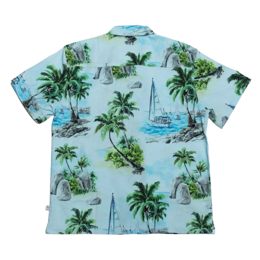 Light blue hawaiian shirt featuring a tropical print with palm trees, sailboats, and rocky islands.