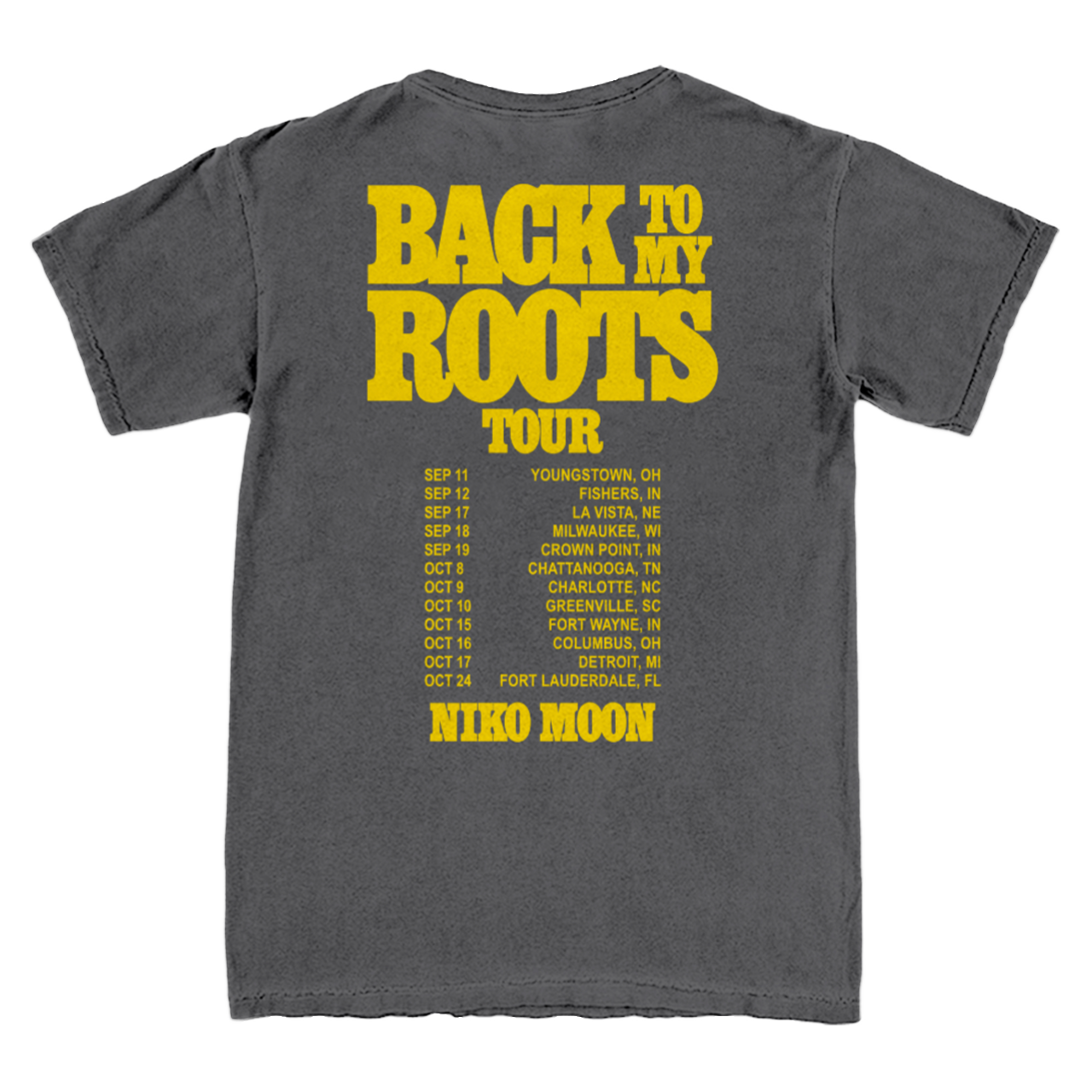 A dark gray t-shirt showing the back side with a large yellow graphic print that reads 'BACK TO MY ROOTS TOUR' and lists tour dates with 'NICO MOON'.