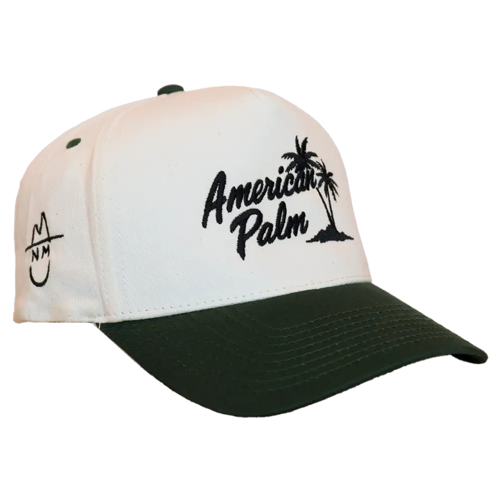 White and dark green baseball cap with black embroidered ’american palm’ text and palm tree design.