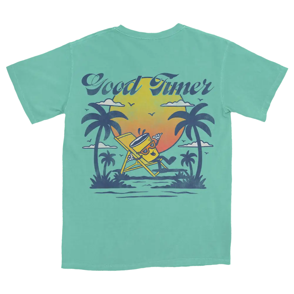 Mint green t-shirt with a tropical beach scene graphic on the back.