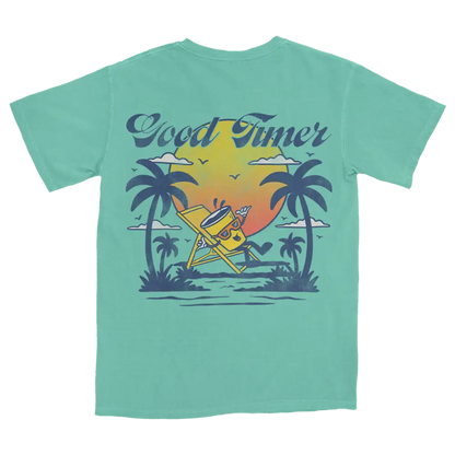Mint green t-shirt with a tropical beach scene graphic on the back.