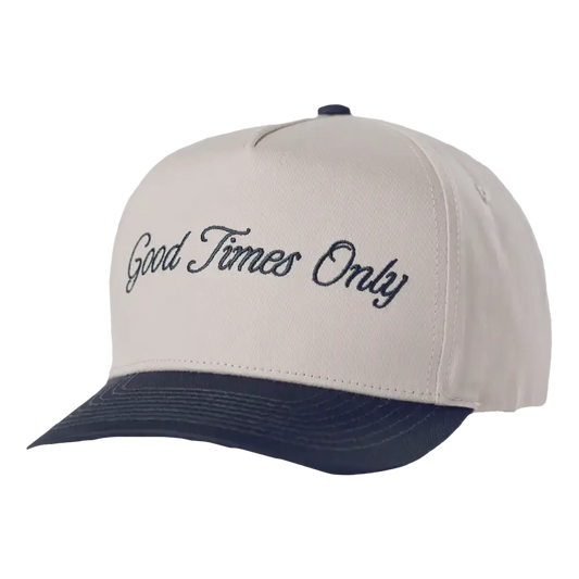 A white and navy blue baseball cap with ’good times only’ embroidered in black cursive script across the front.