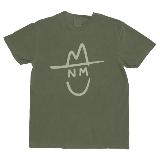 Olive green cotton t-shirt featuring a white stylized graphic of a smiling face wearing a hat with ’nm’ initials.