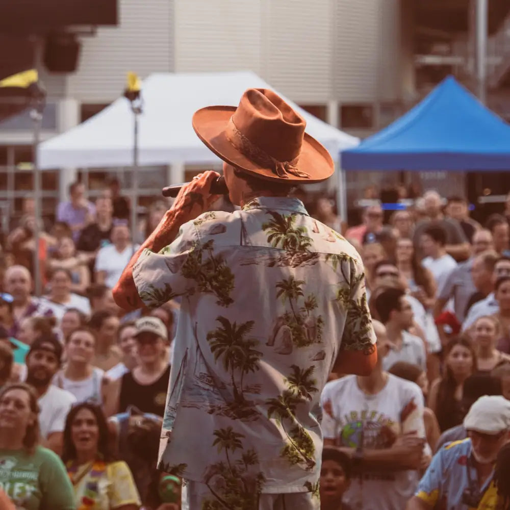 A brown leather cowboy hat with a decorative band and fringe.