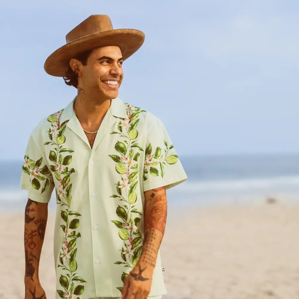 Light green short-sleeved button-up shirt with a tropical leaf and fruit pattern