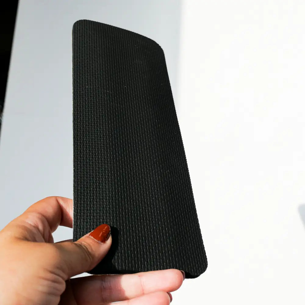 Black textured yoga mat with a woven pattern.