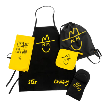 Collection of branded kitchen accessories including an apron, oven mitt, drawstring bag, and notebook featuring a yellow and black color scheme with a smiley face logo.