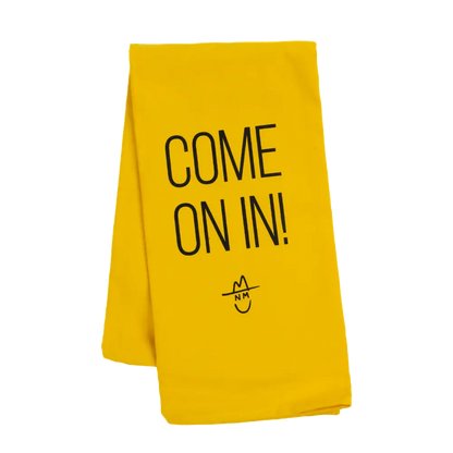 Bright yellow towel or cloth with ’COME ON IN!’ printed in black text and a simple smiley face design.